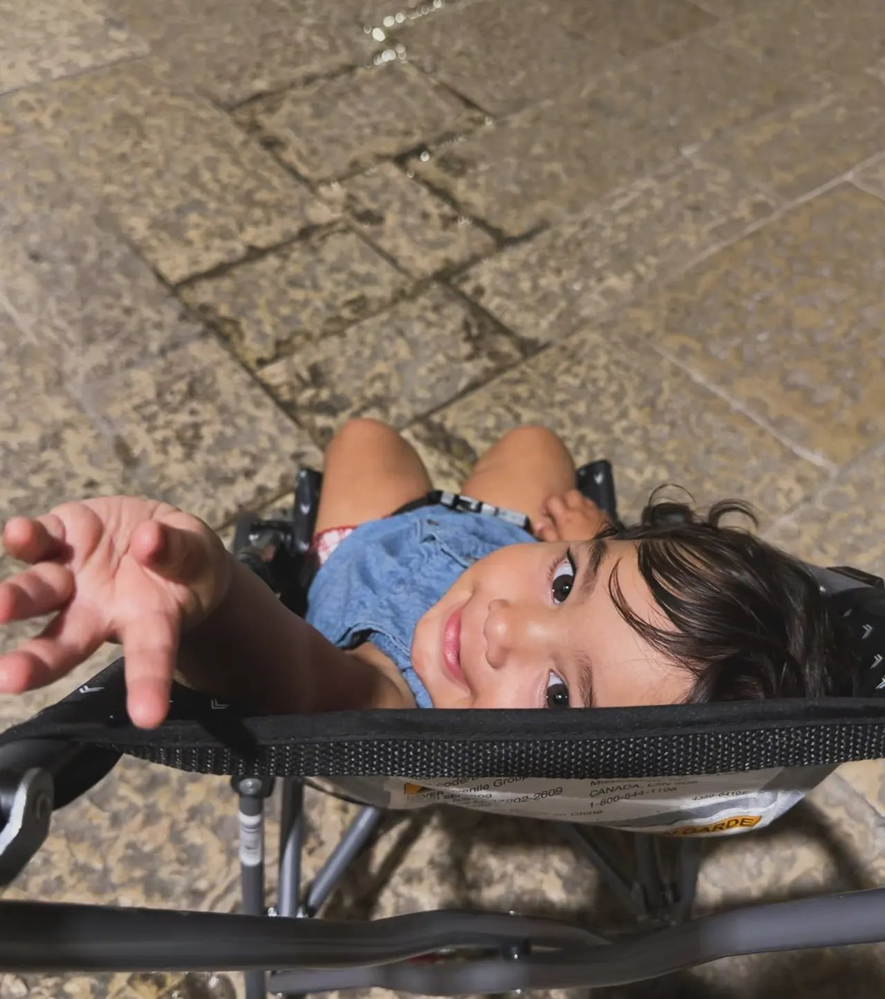 A baby in a stroller, seen from above